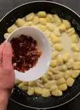 Immagine del passaggio 5 della ricetta Gnocchi con crema di gorgonzola, speck e noci