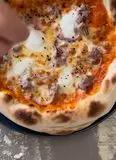 Immagine del passaggio 13 della ricetta Pizza con crema di peperone, salsiccia, cipolla di Tropea e polvere di olive nere