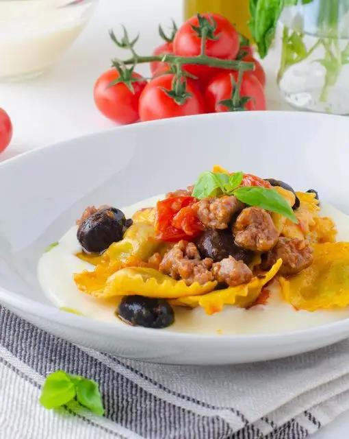 Ricetta Ravioli ricotta e spinaci con fonduta di canestrato con olive nere e salsiccia di PAF