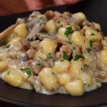 Immagine del passaggio 6 della ricetta Chicche di patate alla fonduta di taleggio con funghi e salsiccia