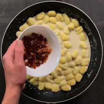 Immagine del passaggio 5 della ricetta Gnocchi con crema di gorgonzola, speck e noci
