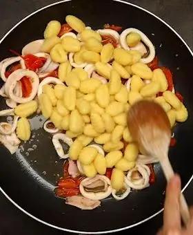 Immagine del passaggio 4 della ricetta Gnocchi con crema di piselli, calamari e pomodorini