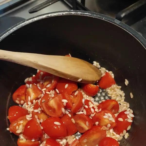 Immagine dello step: Far soffriggere lo scalogno tritato con un filo d'olio d'oliva e aggiungere i pomodorini tagliati a pezzetti.