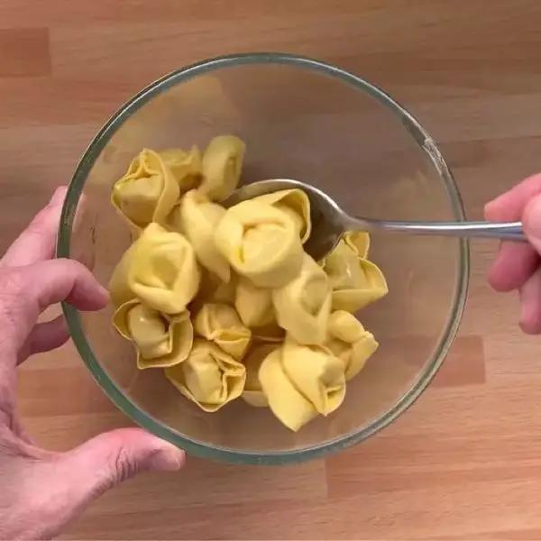 Immagine dello step: Mettere i Cappelletti in una ciotola capiente e distribuire l’olio uniformemente da avvolgere tutta la pasta