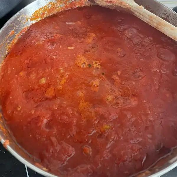 Immagine dello step: Aggiungere 2 bottiglie di salsa di pomodoro e lasciare cucinare il sugo a fiamma bassa