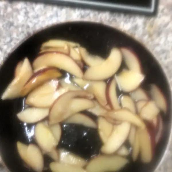 Immagine dello step: Lavare le mele, tagliarle a fettine mantenendo la buccia. In una padellina far sciogliere il burro, aggiungere le mele e farle rosolare per un paio di minuti. Aggiungere poi i due cucchiai di zucchero e farle caramellare.