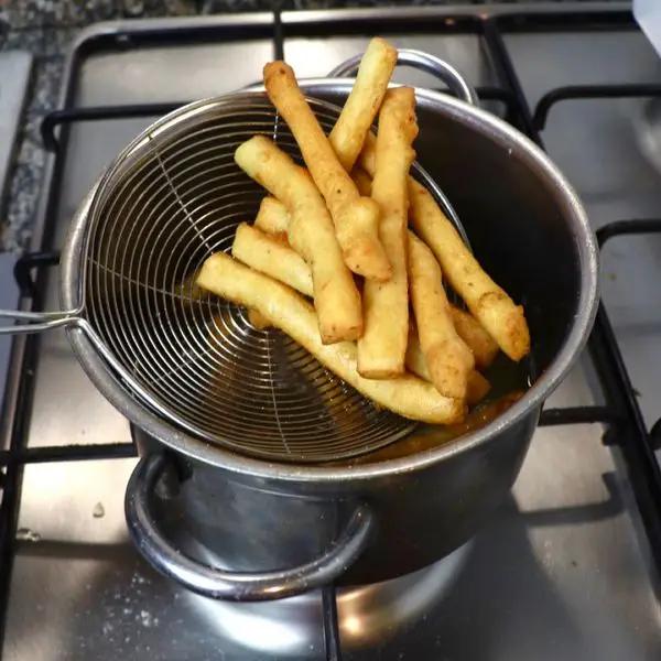 Immagine dello step: Friggette le vostre patatine fino a che diventano dorate, dopo di che scolate e passateli nella carta assorbente come le classiche patatine fritte. Servite subito calde oppure tiepide.
