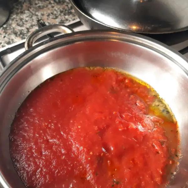 Immagine dello step: In un altra casseruola scaldare l altro cucchiaio d olio, con peperoncino tritato e salsa di pomodoro. Fate cuocere 30 minuti a fuoco lento