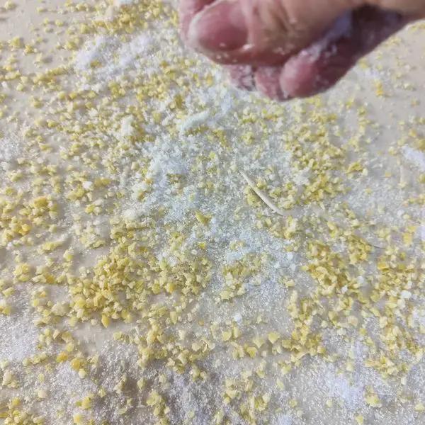 Immagine dello step: Si sparge la granella di limone e zucchero su tutta la superficie. Poi si arrotola un filone fino alla metà . Poi si arrotola l'altra metà e si sovrappone e si crea un unico filone.