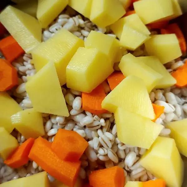 Immagine dello step: Pelate l’altra carota e le patate e tagliatele a tocchetti. Aggiungetelo all’orzo.