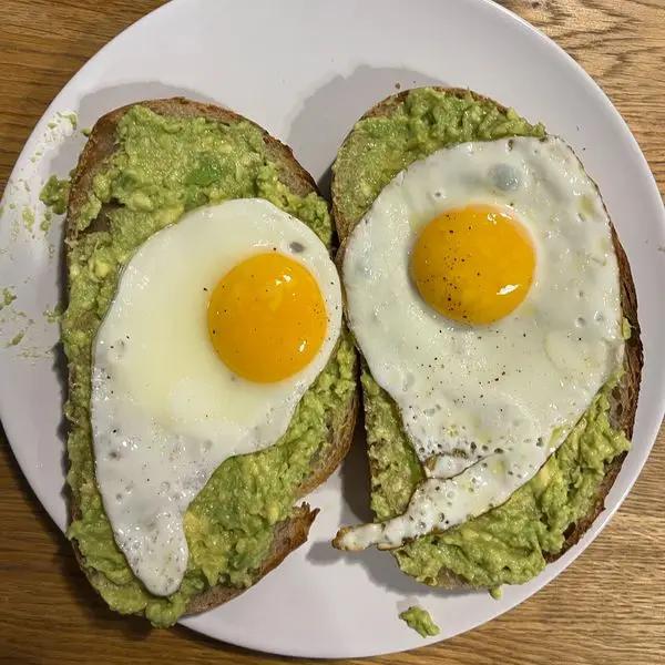 Immagine dello step: Spalmare sul pane l’avocado e posizionare un uovo su ogni fetta