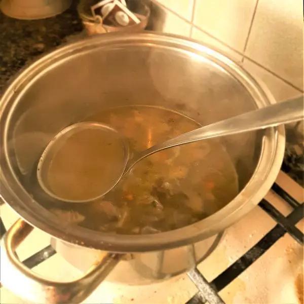 Immagine dello step: Versate nella pentola 5-6 mestoli di brodo bollente, portate a ebollizione e lasciate cuocere lentamente per altri 20 minuti.