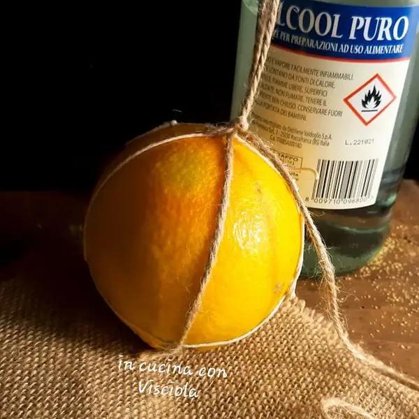Immagine dello step: Lavate e asciugate un'arancia e legatela con dello spago