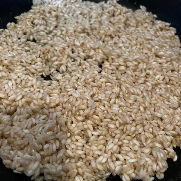 Immagine dello step: Fai tostare il riso a secco e sfuma con del vino bianco.