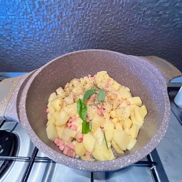 Immagine dello step: Aggiungi le patate e fai rosolare, con rosmarino, salvia, basilico, sale e pepe.