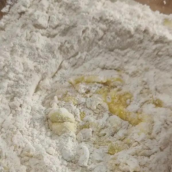 Immagine dello step: Impastare nella planetaria o in una ciotola la farina con le uova leggermente sbattute, unire lo zucchero, la panna,  la grappa ed il sale.