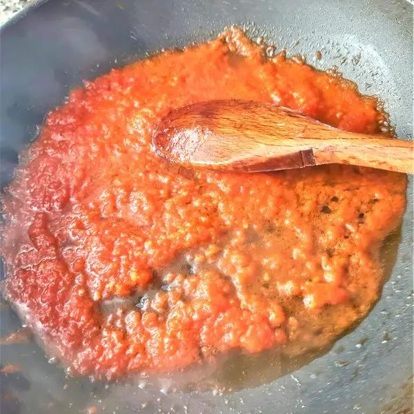 Immagine dello step: Intanto, fate soffriggere l'aglio tritato nell'olio evo e unite la salsa, fatela cuocere 10 minuti