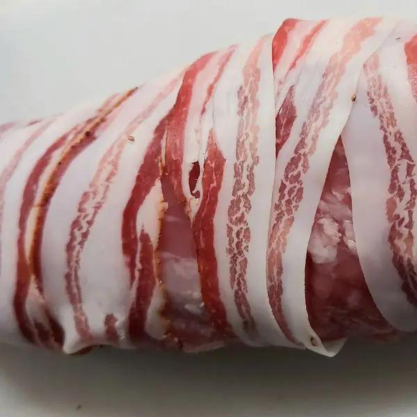Immagine dello step: Avvolgete il filetto di maiale con le fette di pancetta, se credete potete legarlo con spago da cucina.